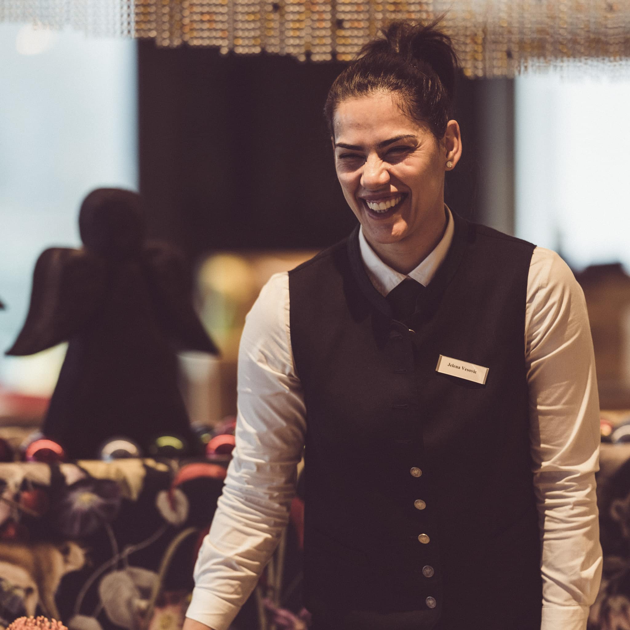 Frau im Service lacht bei der Arbeit im Eibsee Hotel